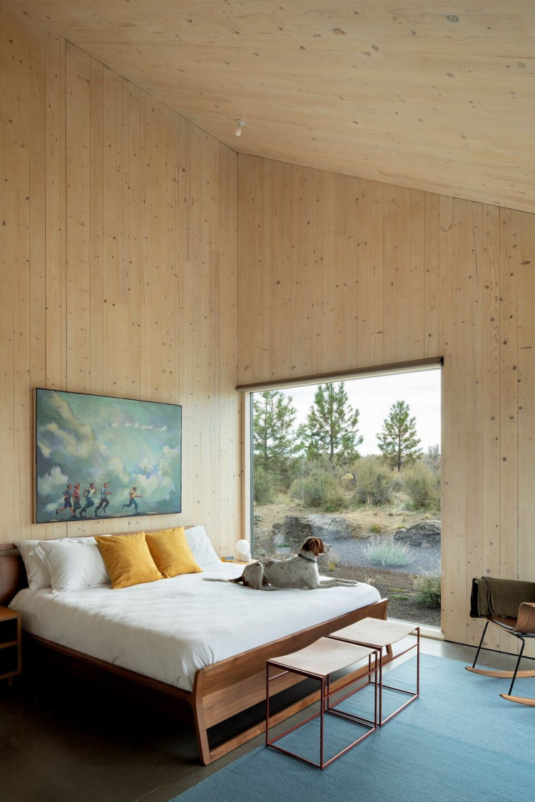 Udobna spavaća soba sa velikim prozorima i zidnim oblogama od unakrsno lameliranog drveta